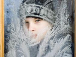 El estudiante Bela Borsy, vestido con ropa de invierno, observa através de la ventana congelada de su clase en la escuela de Nagykallo, 235 kms al este de Budapest, Hungría. / Efe
