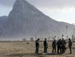 Varios agentes de la Guardia Civil junto al cadáver del inmigrante que ha sido localizado en la playa de Levante del municipio de La Línea de la Concepción. /Efe