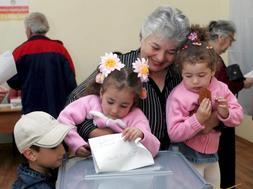 Una mujer ejerce su derecho al voto junto a sus nietos en un colegio electoral de la localidad de Tskhinvali, Osetia del Sur (Georgia) ./ Efe