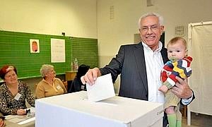 El candidato del partido conservador Fidesz, Peter Szalay, deposita junto a su nieto, su voto en la urna de un colegio electoral en Budapest / EFE