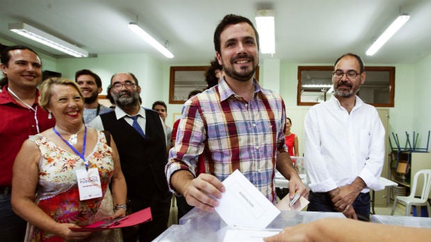 Garzón votando con el personaje del Mocito feliz -de negro- a sus espaldas