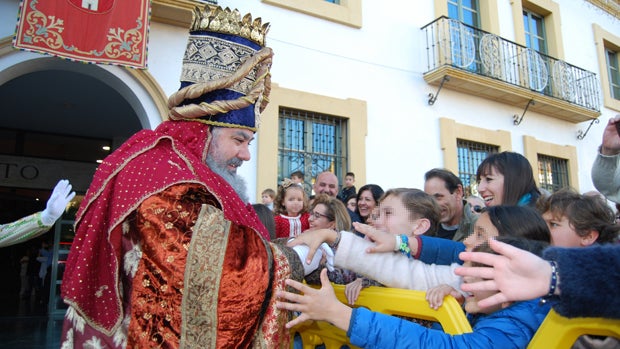 Uno de los Reyes Magos saluda a los niños