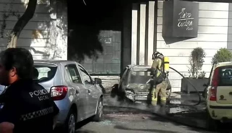 Unos encapuchados empotran y queman un coche en la puerta de una discoteca en la Cartuja en Sevilla