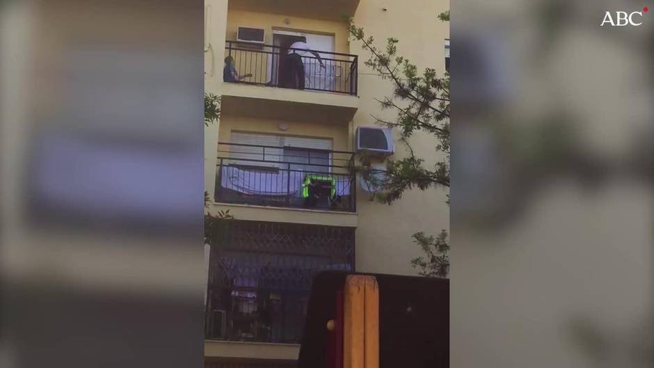 Un hombre trepa por la fachada de una vivienda para auxiliar a una mujer que había quedado atrapada por el fuego