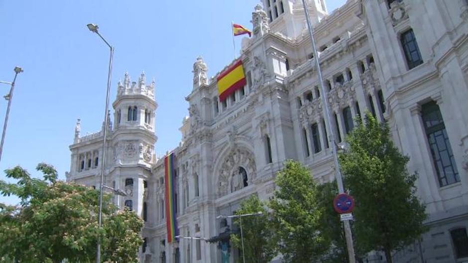 La bandera LGTBI se despliega en un lateral de la fachada de Cibeles