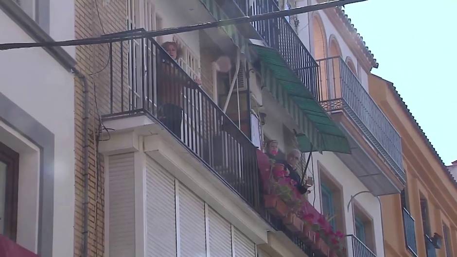 Vecinos de la trianera calle de Pureza (Sevilla) rezan el Ángelus a las puertas de la Semana Santa