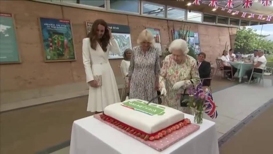 La reina Isabell II corta una gran tarta con una espada en un evento solidario en Reino Unido