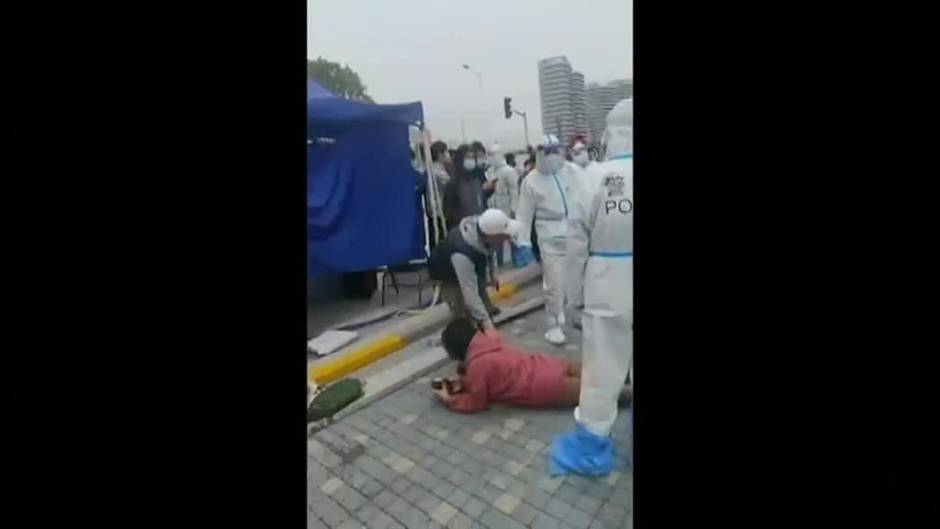 Habitantes de Shanghái confinados se enfrentan a la policía