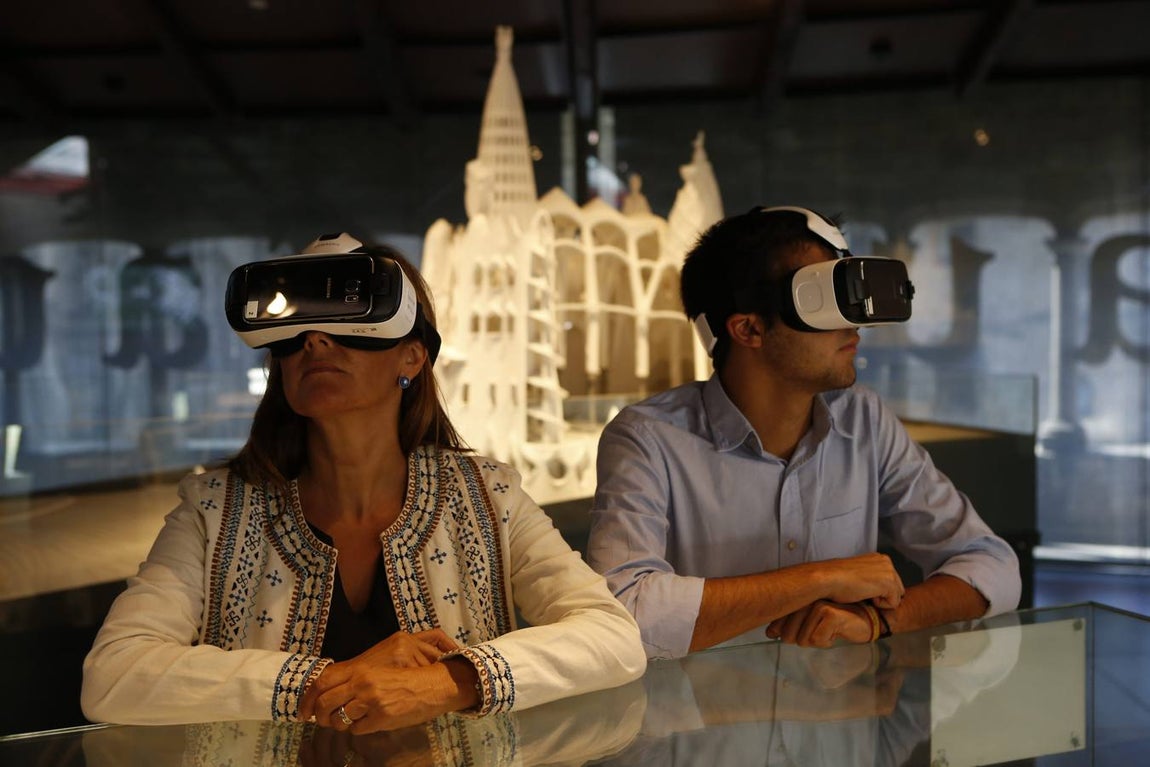 Dos visitantes con gafas de realidad virtual en la exposición