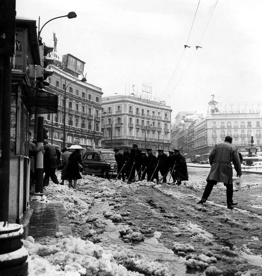 16.. Operarios retirando nieve, en la Puerta del Sol, en 1960