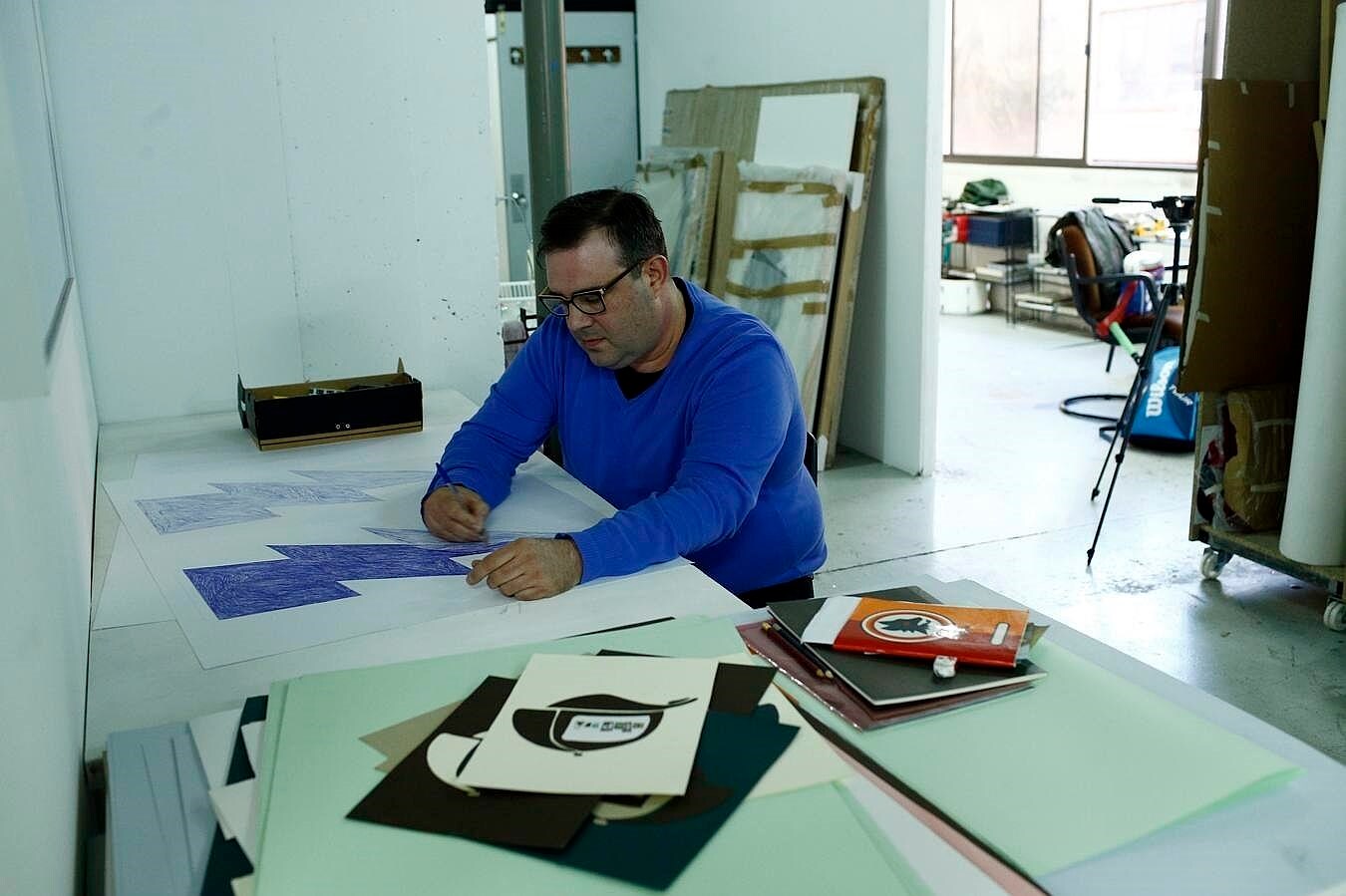 Toni Ramón dibuja en su mesa, cerca del espacio de Miki Leal y Sonia Navarro