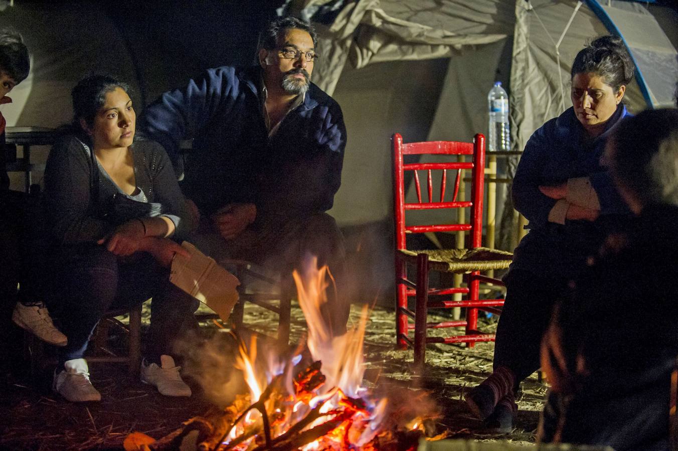 Las familias se calientan con una hoguera. 