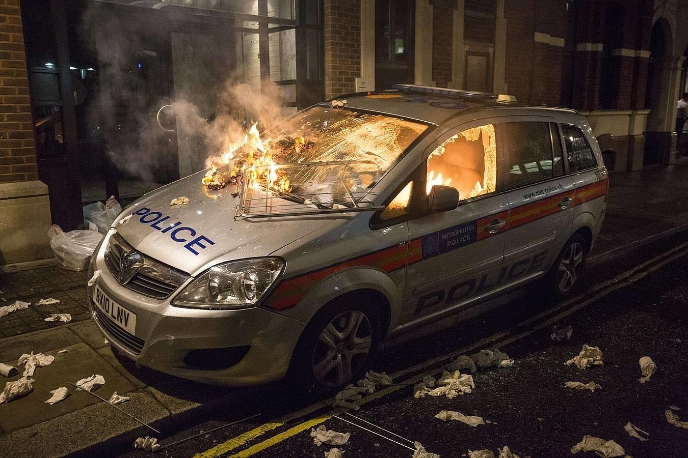 Un coche de la Policía quemado durante la manifestación de «Anonymous» de este jueves en Londres. 