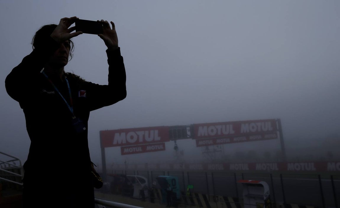 Una joven toma una imagen esta mañana en el circuito Ricardo Tormo de Cheste, Valencia, que ha amanecido con una densa niebla