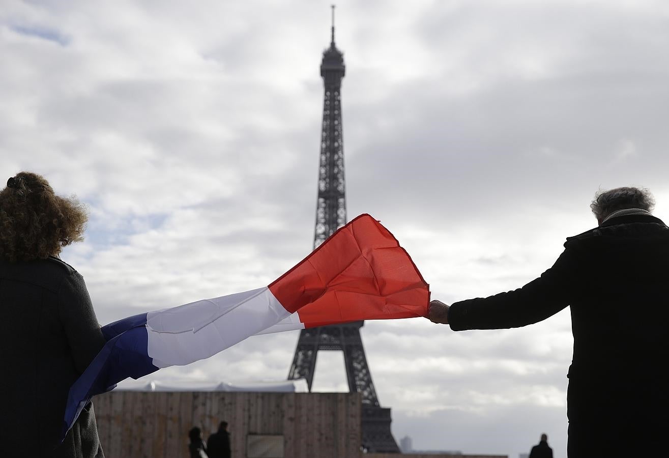 Un hombre con una bandera durante el minuto de silencio en la Place de Trocadero en Paris. 