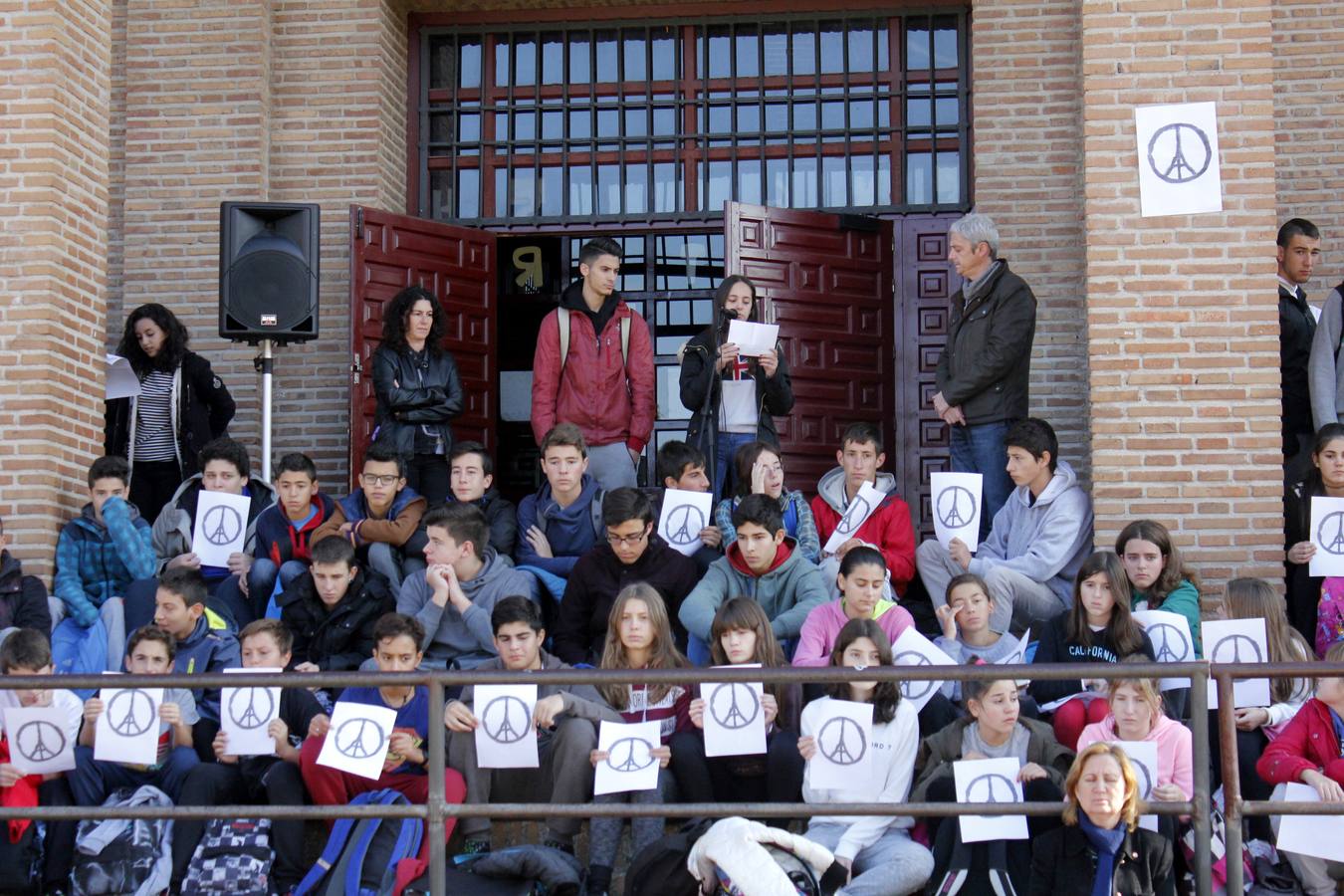 Los estudiantes han tomado asiento portando cartulinas con uno de los símbolos que más ha circulado estos días por las redes sociales, el de la torre Eiffel encuadrada en el símbolo de la paz. 