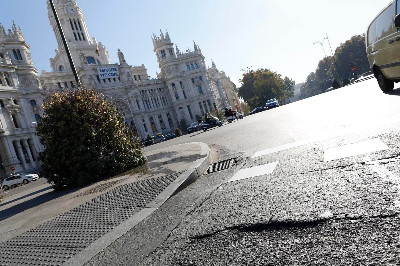 6. En la plaza de Cibeles, frente a la sede del Ayuntamiento, turistas y madrileños contemplan las grandes irregularidades del asfalto