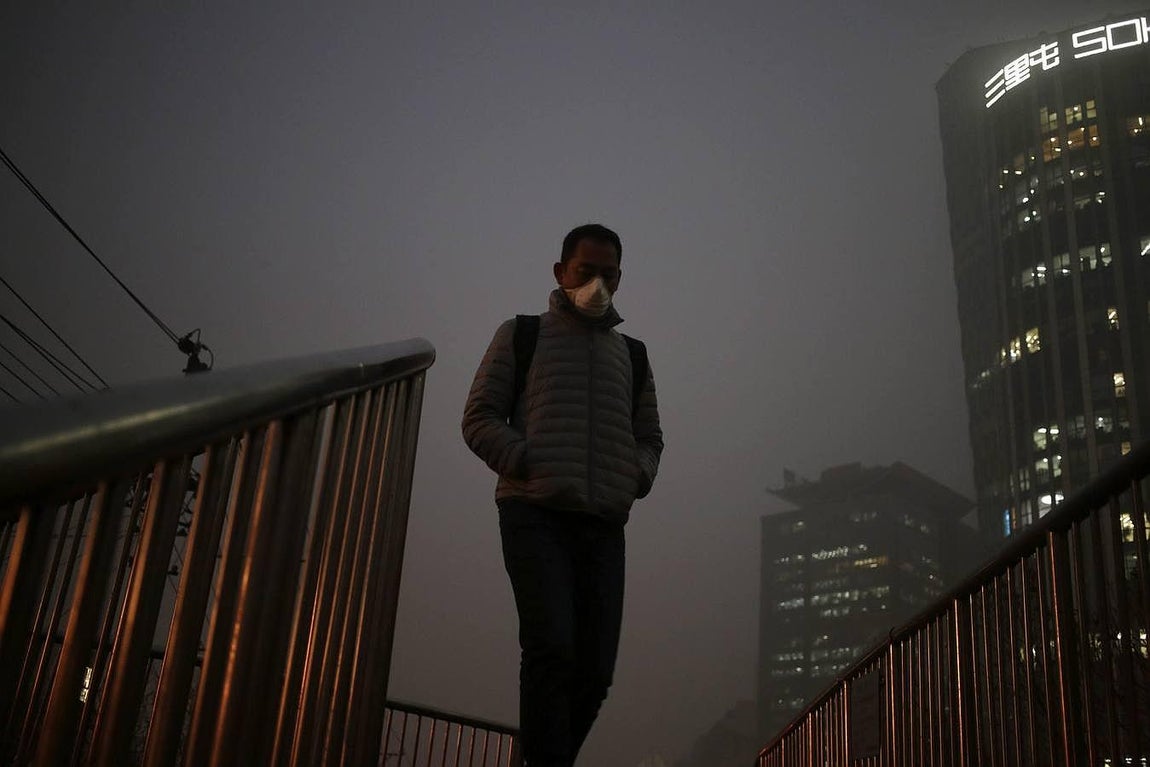 Un hombre pasea por las calles de Pekín con una mascarilla