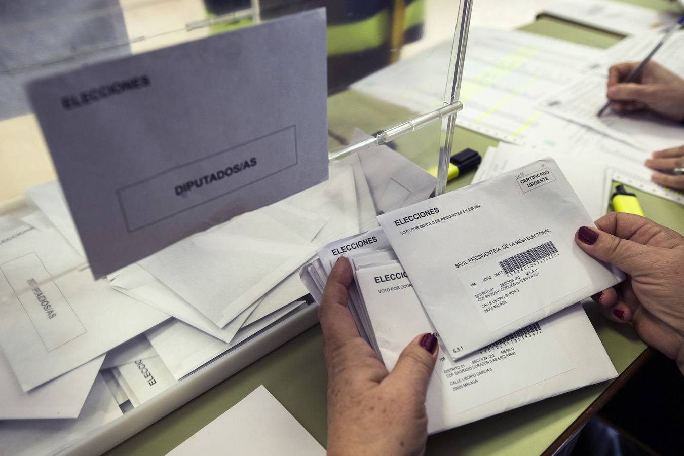 La presidenta de una mesa electoral certifica los votos por correo a primera hora de la mañana en un colegio de Málaga