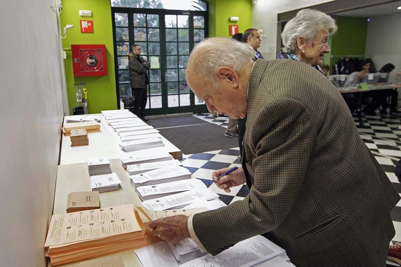 El expresidente de la Generalitat Jordi Pujol, junto a su esposa, Marta Ferrusola, coge sus papeletas en el colegio electoral de Barcelona donde ha votado esta mañana.. 