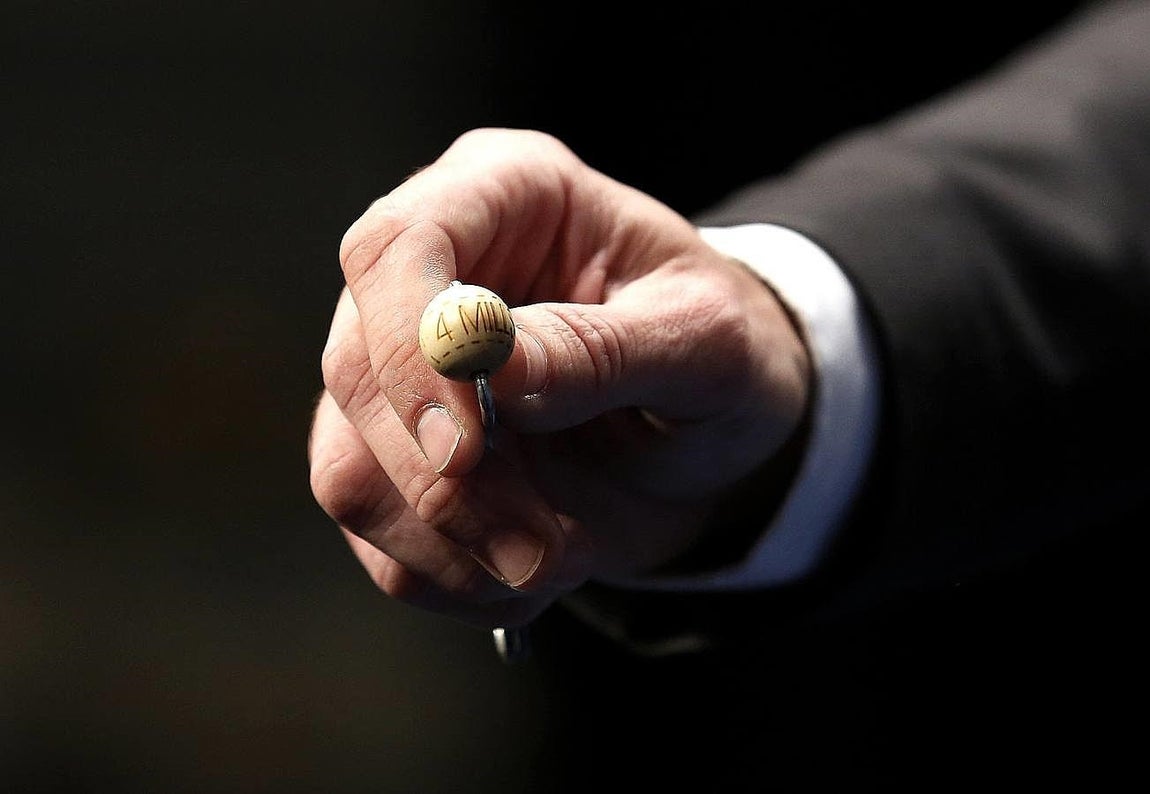 Un funcionario de Loterias y Apuestas del Estado muestra la bola con el primer premio de la Loteria de Navidad que hoy se celebra en el Teatro Real ante de introduc irla en el bombo.. 