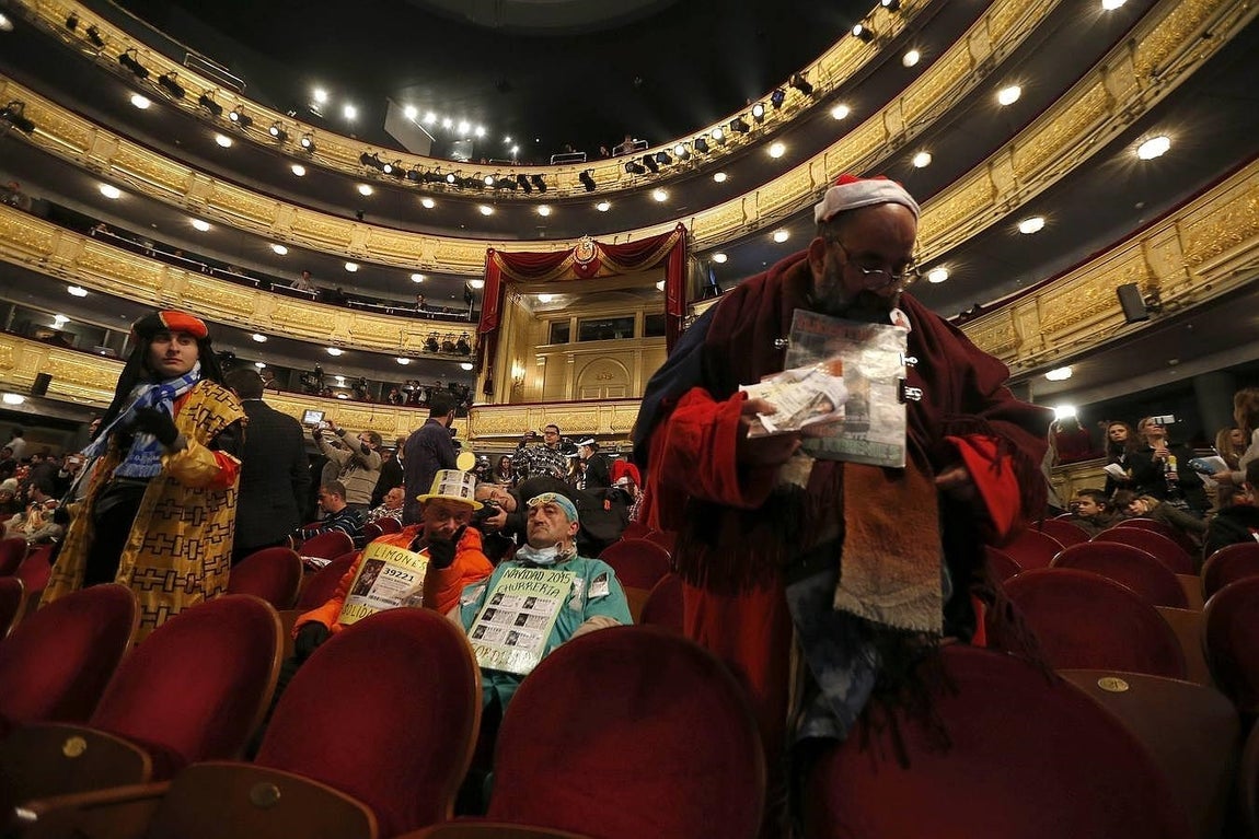 El conocido como «Mocito Feliz» (d), junto a otras personas disfrazadas, espera en el interior del Teatro Real a que dé comienzo el Sorteo Extraordinario de Navidad, para vivir de cerca el instante en que los niños de San Ildefonso canten el Gordo. Los bombos de la Lotería de Navidad girarán desde las nueve de esta mañana para repartir 2.240 millones de euros en premios, de los que 640 millones corresponderán al Gordo (400.000 euros por décimo). 