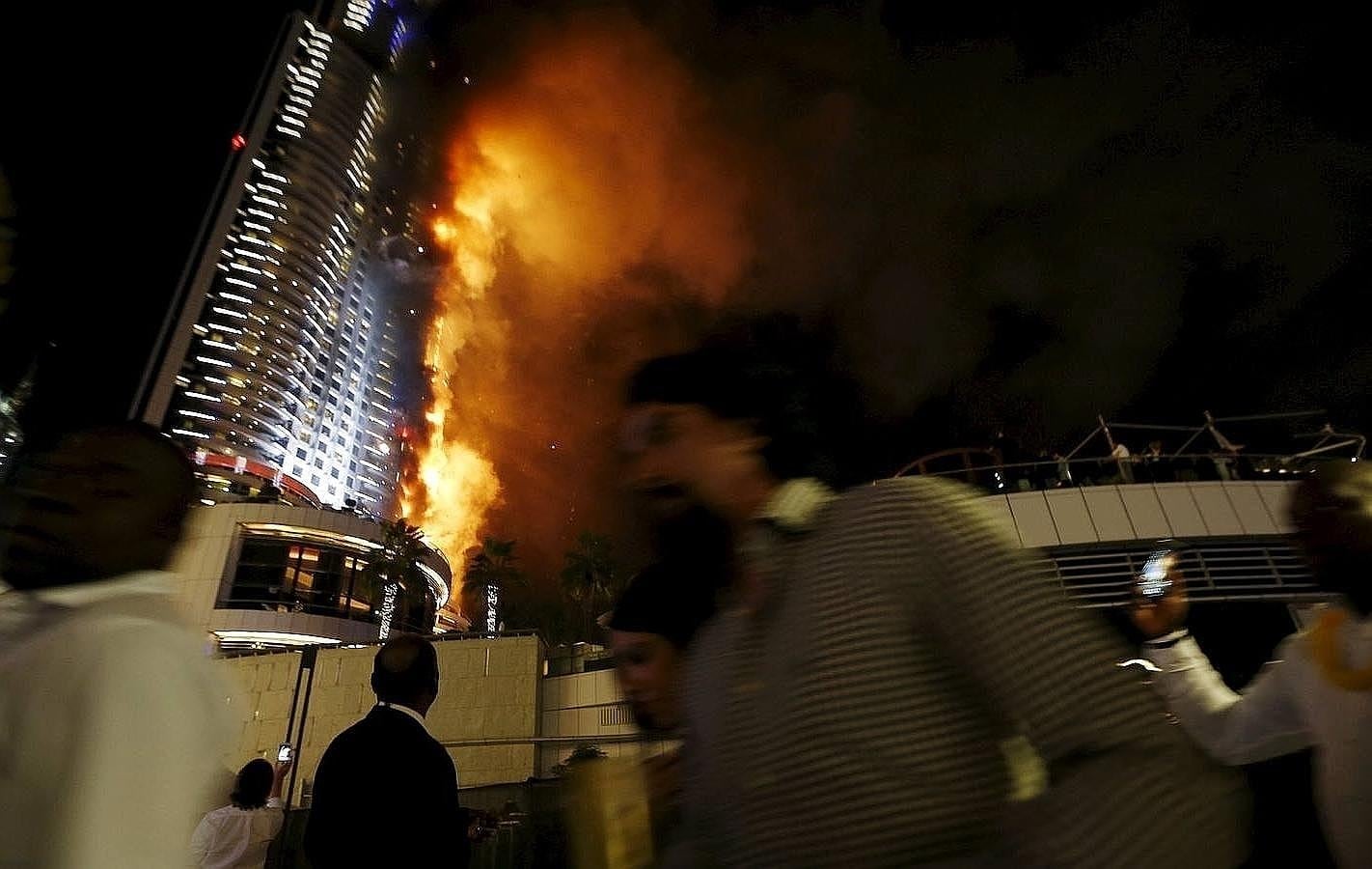 Los cascotes caen durante el incendio en el rascacielos de Dubai. 