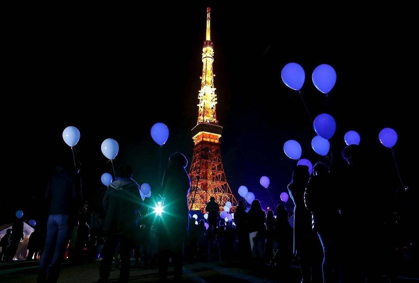 Un grupo de personas celebra el Año Nuevo con globos frente a la Torre de Tokio, en Tokio, Japón. 