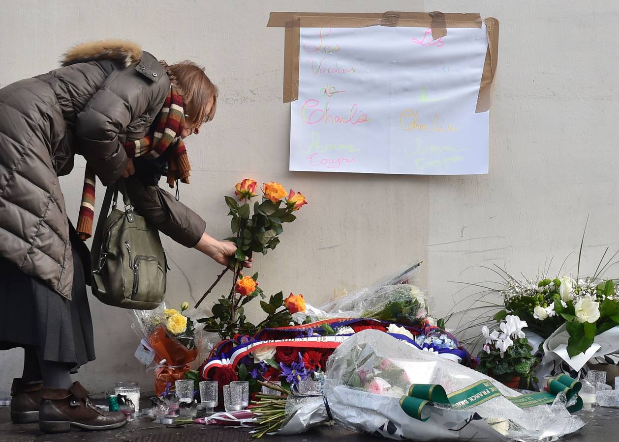 Una ciudadana francesa deposita flores. 