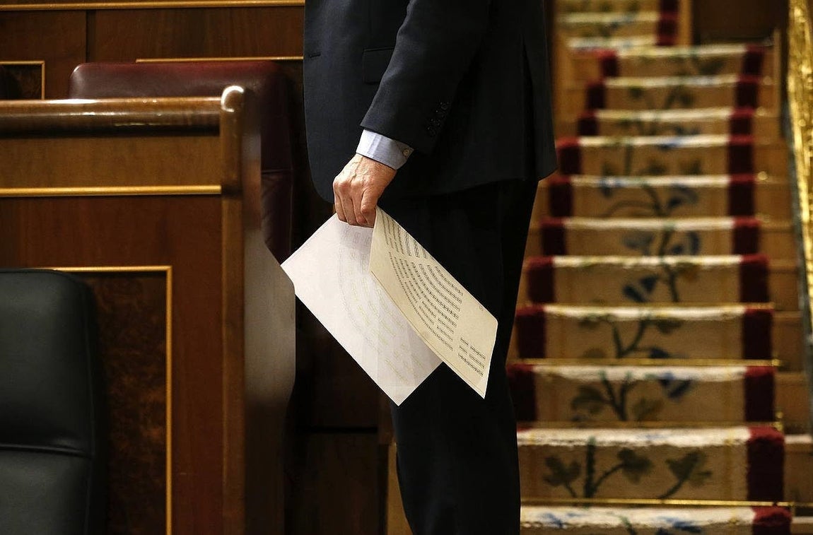 Un diputado sostiene un del nuevo hemiciclo en la sesión. 