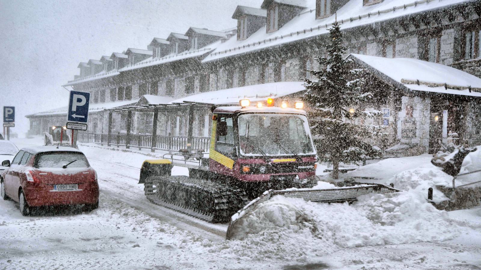 Una máquina quitanieves retira la nieve acumulada en la estación de esquí de los Llanos del Hospital, en el valle de Benasque, cuya carretera de acceso, la A-139, está limitada al tráfico con cadenas. 