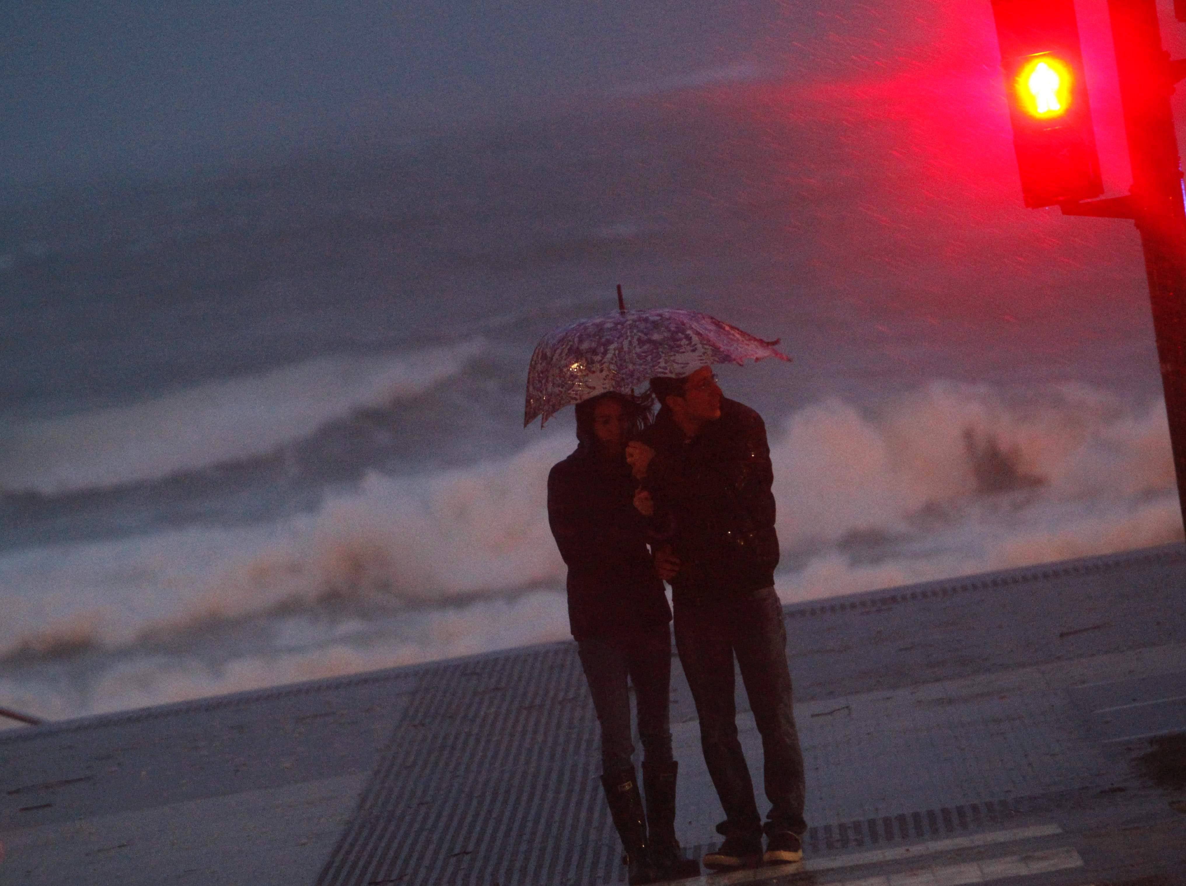 Una pareja resiste con un paraguas en la playa de Riazor. 