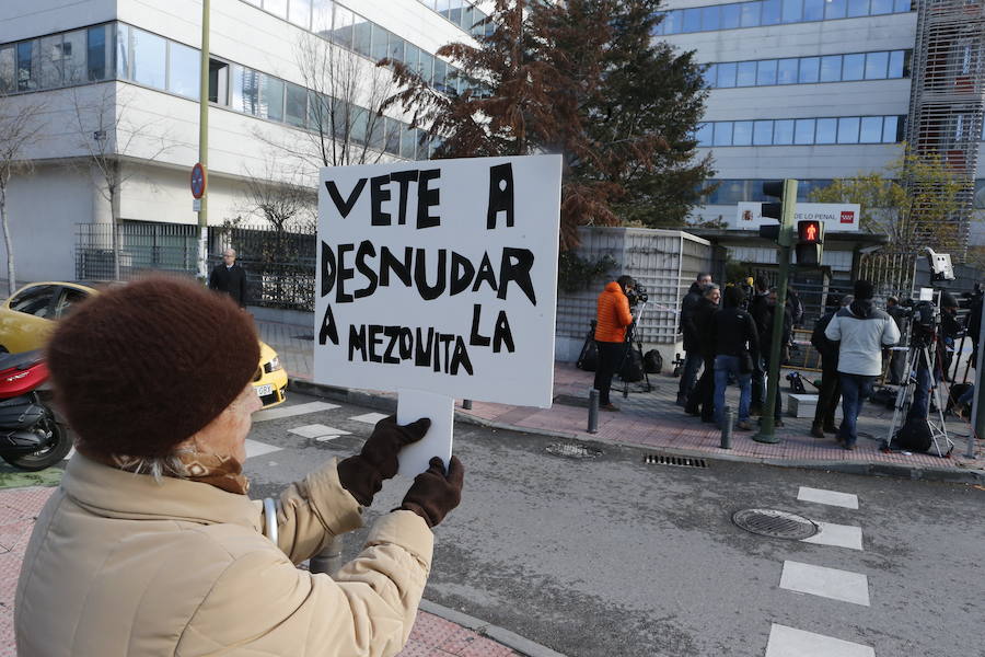 Una mujer sostiene un cartel a la entrada del Juzgado en el que se lee: «Vete a desnudar a la mezquita». 