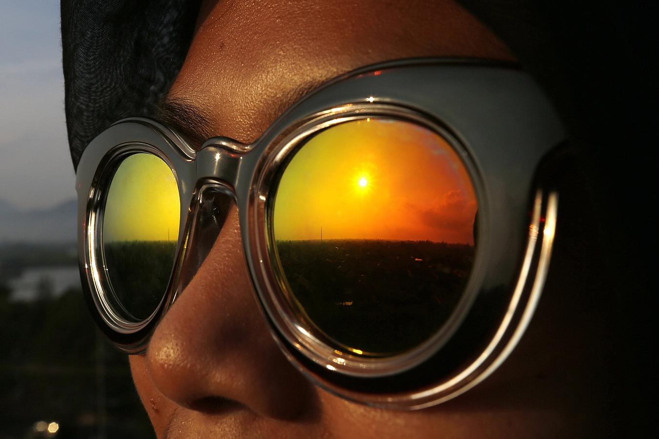 El eclipse parcial de sol reflejado en las gafas de una mujer en Indonesia. 