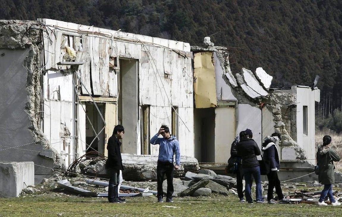 Un grupo de visitantes muestra sus respetos a las víctimas visitando la devastada escuela primaria de Ishinomaki, la perfectura de Miyagi (Japón) este 10 de marzo de 2016. 