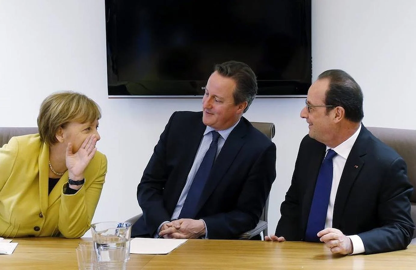 Angela Merkel, David Cameron (c) y François Hollande comparten confidencias durante la cumbre de la Unión Europea de este viernes en Bruselas, en la que se llegó a un acuerdo con Turquía sobre los refugiados