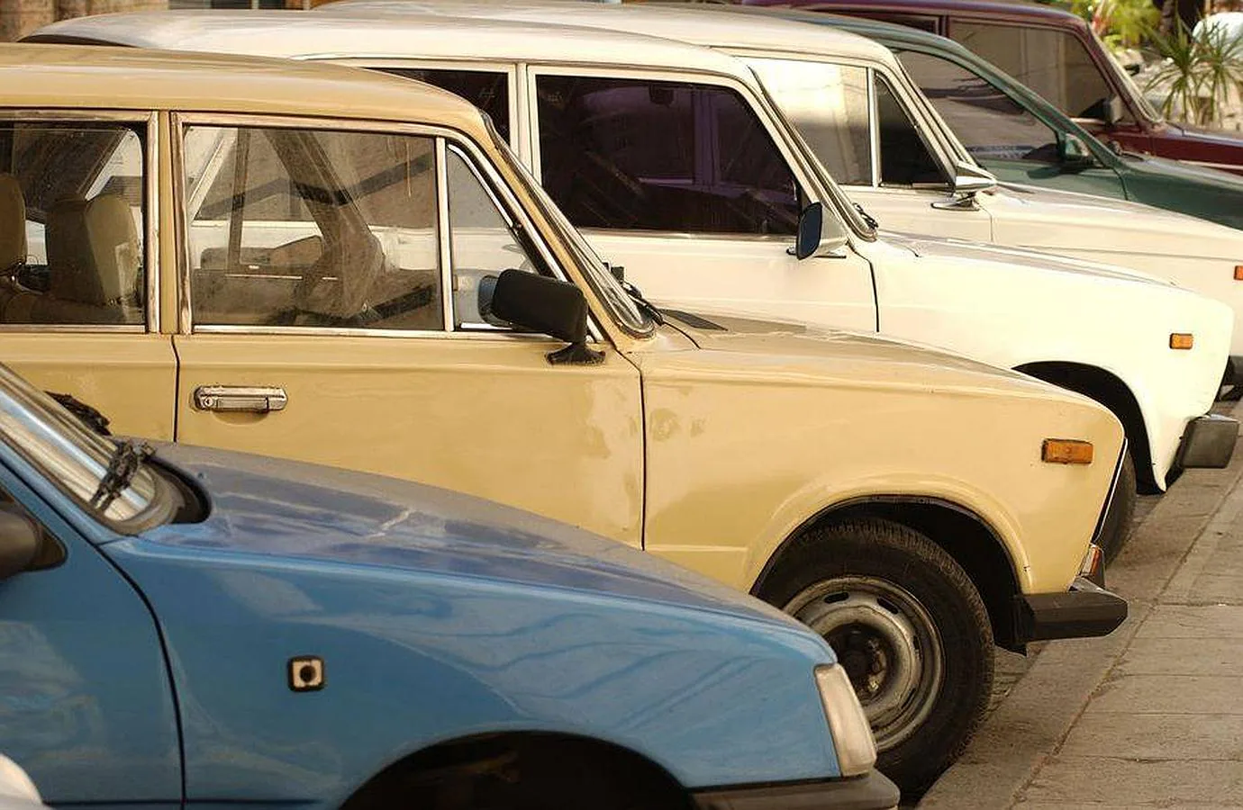 Un Peugeot 205 en primer plano, y varios Lada importados de Rusia