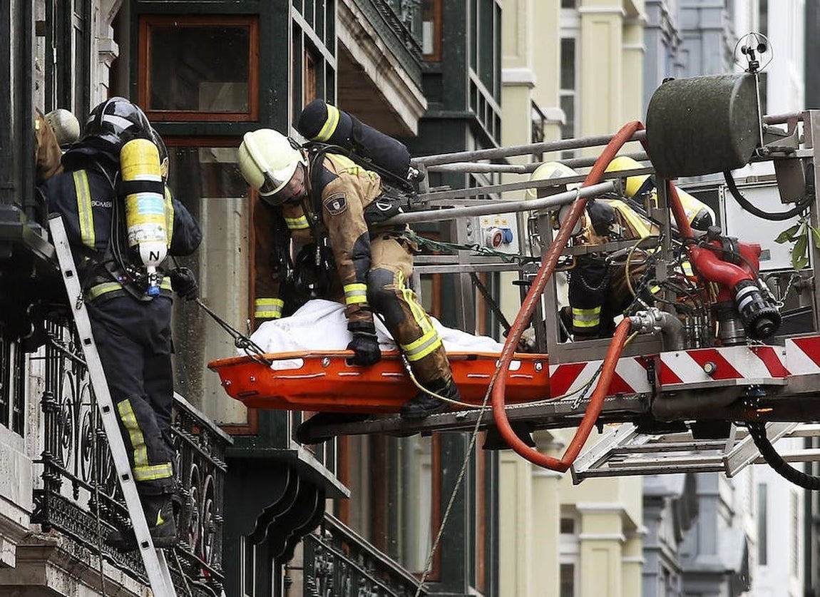 Los bomberos sacan el cadáver de su compañero fallecido. 