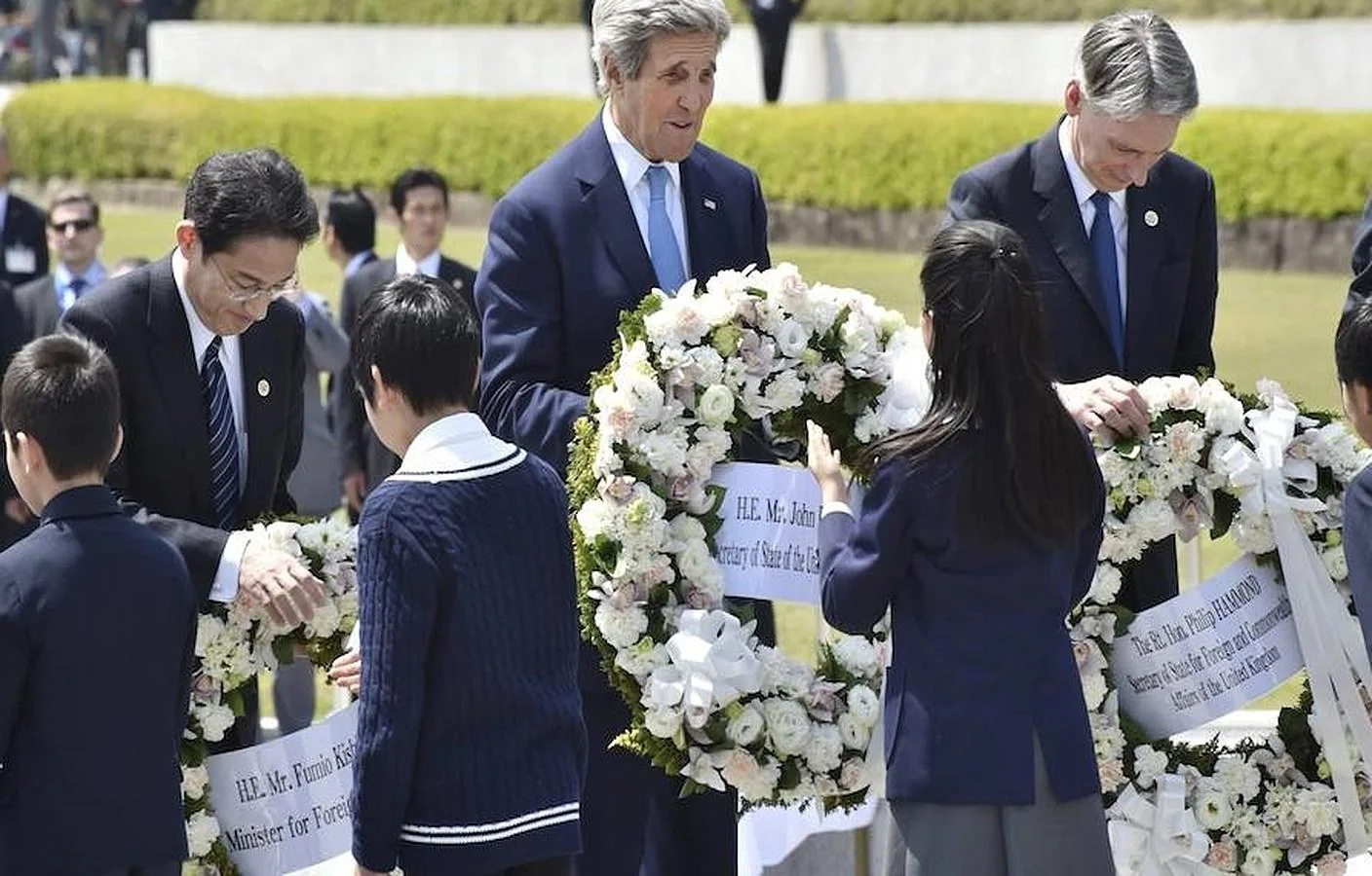 El ministro de Exteriores nipón, Fumio Kishida (i), el secretario de Estado de EE. UU., John Kerry (c), y el ministro de Exteriores británico, Philip Hammond, depositan una corona de flores por las víctimas de la bomba atómica de 1945, este lunes en el parque conmemorativo de la paz de Hiroshima 