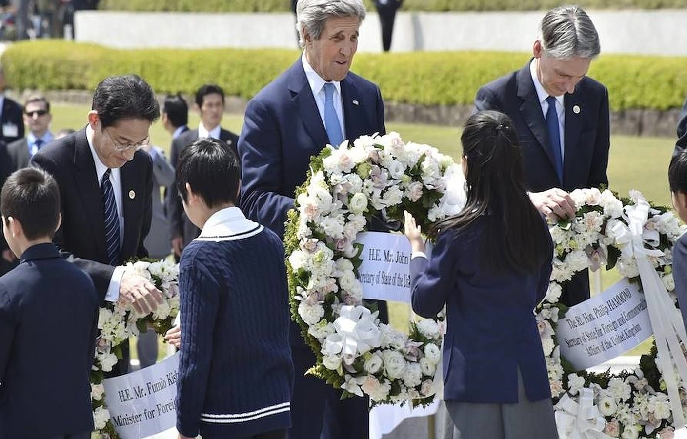 El ministro de Exteriores nipón, Fumio Kishida (i), el secretario de Estado de EE. UU., John Kerry (c), y el ministro de Exteriores británico, Philip Hammond, depositan una corona de flores por las víctimas de la bomba atómica de 1945, este lunes en el parque conmemorativo de la paz de Hiroshima. 