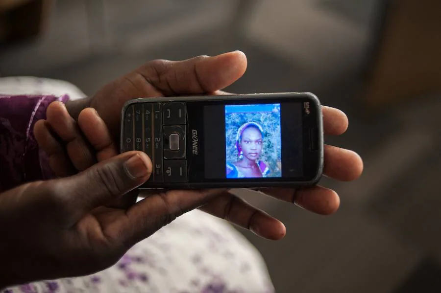 Yana Galang, madre de Rifkatu Galang, una de las niñas de la aldea de Chibok (norte de Nigeria) secuestradas por los terroristas de Boko Haram hace justo dos años, muestra una imagen de su hjja en un móvil durante una entrevista en Lagos