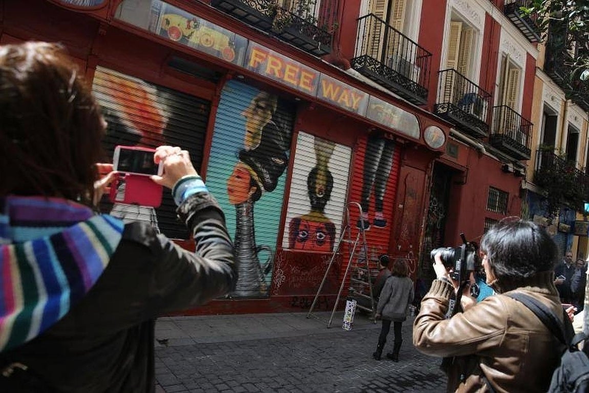 1.. Un centenar de artistas pintaron de forma simultánea los cierras de tiendas del barrio de Malasaña este domingo