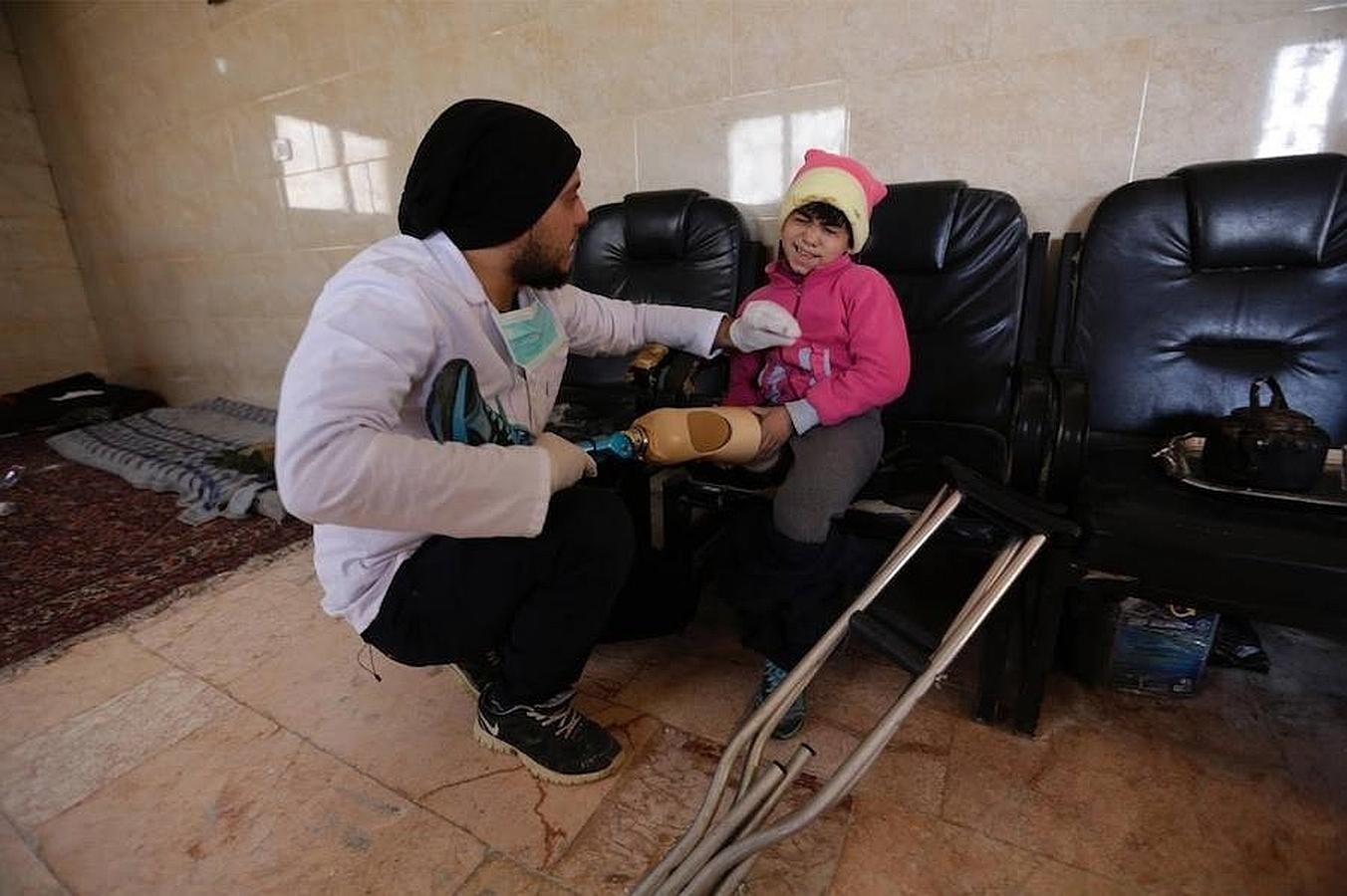 Khamis encaja una pierna artificial a Salma, una niña mutilada por una mina