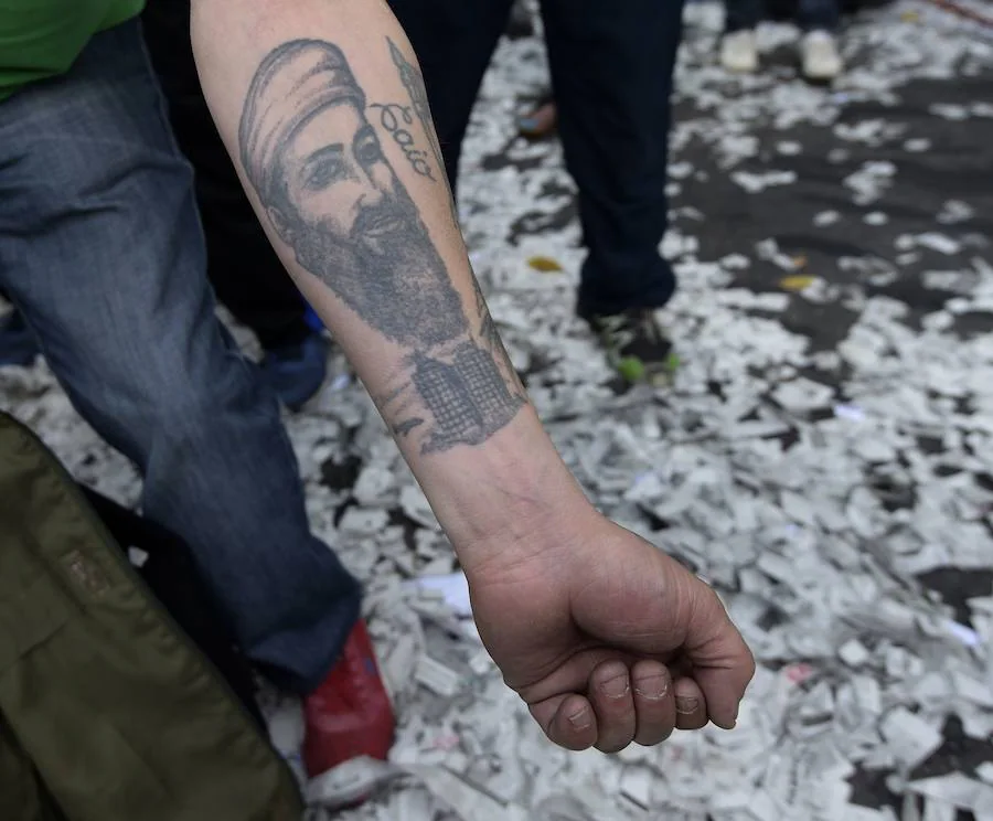 El recuerdo de un terrorista. Un hombre muestra un brazo tatuado con el rostro de Osama bin Laden y un avión antes de chocar contra las Torres Gemelas de Nueva York, en una marcha en Buenos Aires contra los recortes del gobierno.