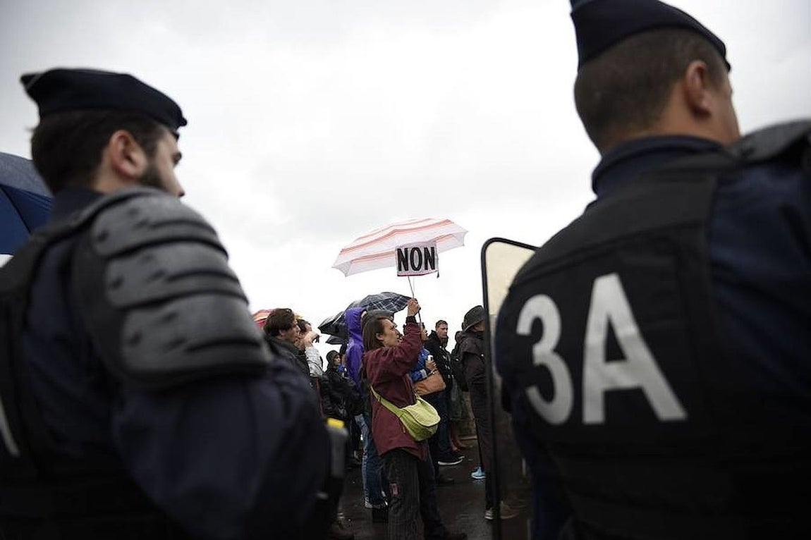 La policía antidisturbios vigila a los manifestantes que protestan cerca del edificio que alberga la Asamblea Nacional, en París. 