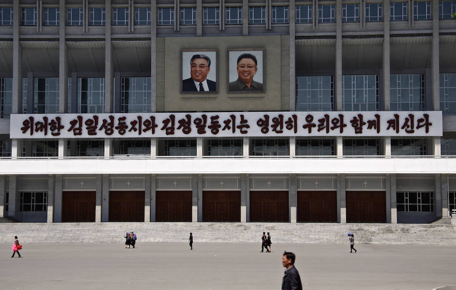 Los norcoreanos aparecen diminutos ante los enormes retratos propagandísticos de Kim Il-sung y Kim Jong-il, abuelo y padre del actual dictador. 