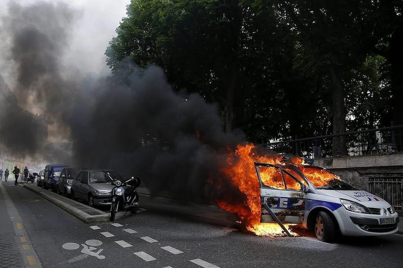 Manifestantes prenden fuego a un coche policial durante una protesta no autorizada contra la violencia policial en las manifestaciones contra la reforma laboral en el país, en París. 