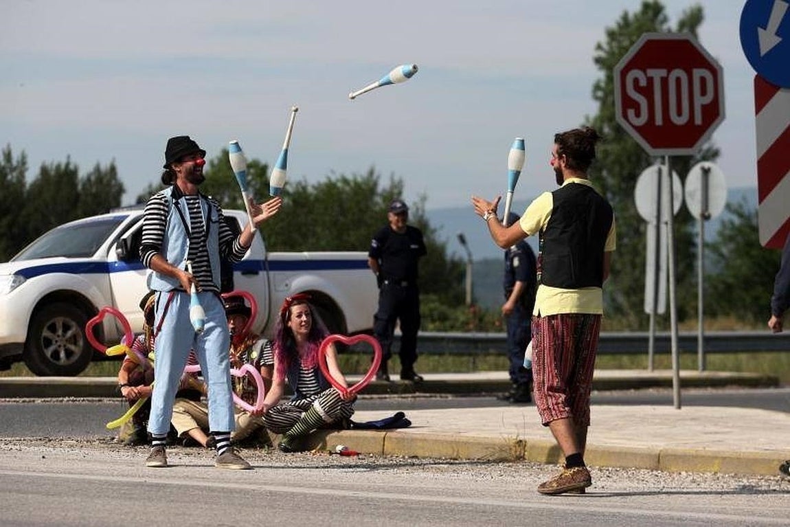 Payasos de un grupo de solidaridad con los migrantes a bordo de un autobús, ya que son evacuados del campamento improvisado en la frontera entre Grecia y Macedonia. 