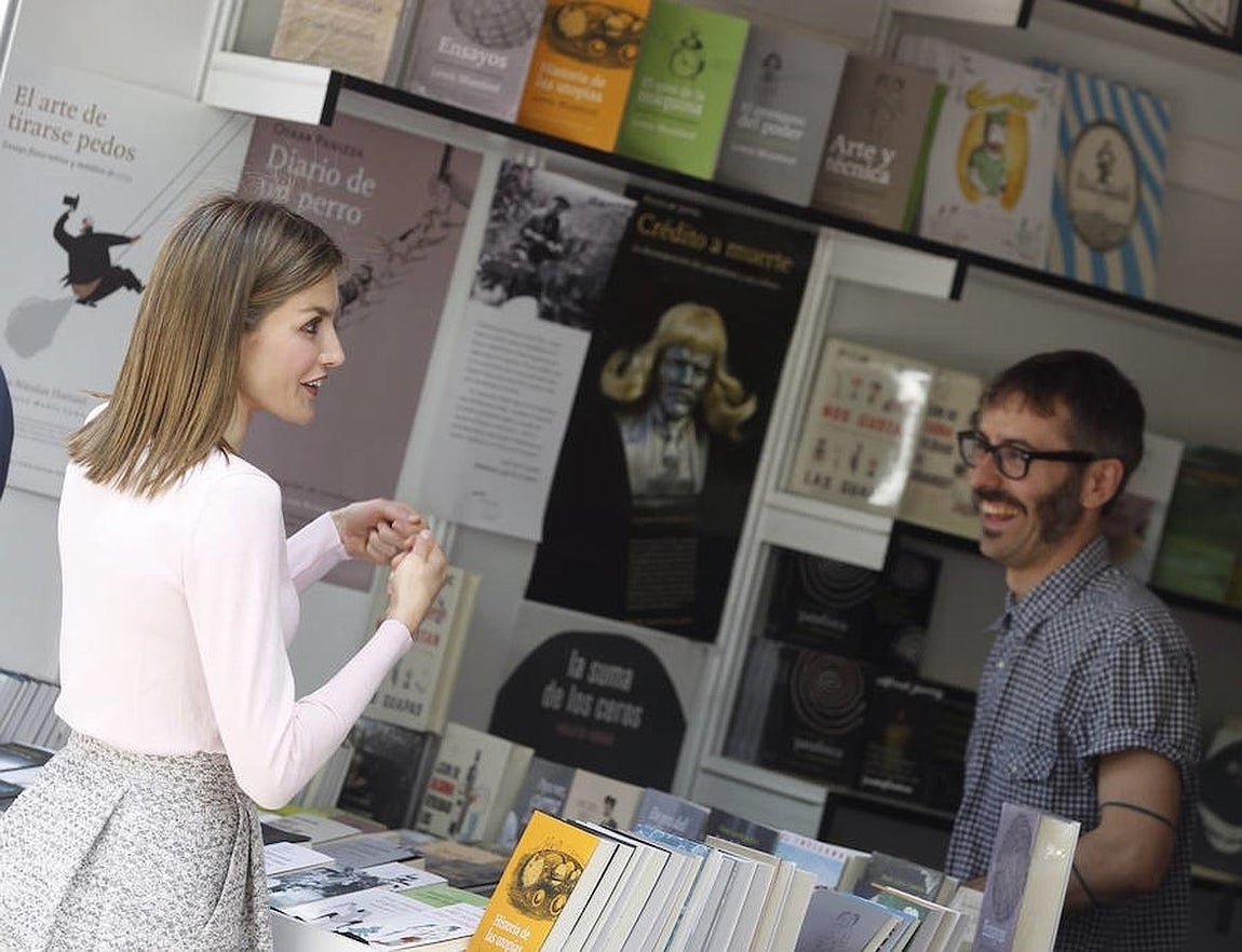 La Reina charla con un librero tras inaugurar la 75 edición de la Feria del Libro. 