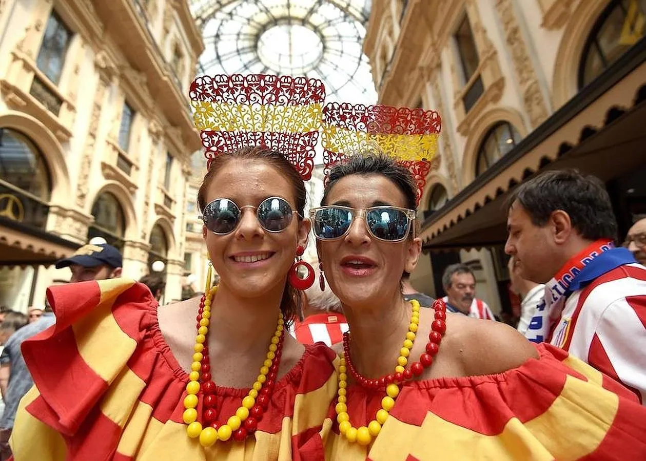 Dos aficionadas españolas vestidas de sevillanas con la bandera nacional en la galería Vittorio Emanuele de Milán. 
